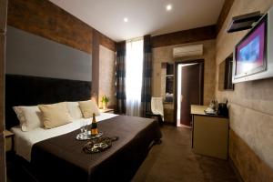 une chambre d'hôtel avec un lit et une télévision dans l'établissement Blue Suite Vatican Guesthouse, à Rome