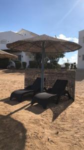 a table and chairs under an umbrella on the beach at Twin Lagoon Apartment at White Villas El Gouna in Hurghada