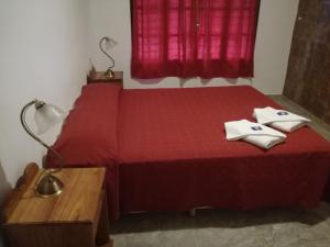 een slaapkamer met een rood bed met 2 kussens erop bij White Field Houses and Spa in Villa Las Rosas +30 foto's