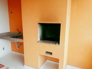 a bathroom with a tv in the corner of a wall at Apto Praia Bertioga - 3 dormitorios sendo uma suite in Bertioga