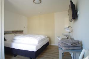um quarto com uma cama, uma televisão e uma mesa em Halte 7 em Kaatsheuvel