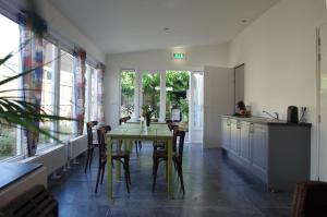 een eetkamer met een tafel, stoelen en ramen bij Halte 7 in Kaatsheuvel