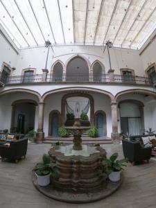 a large stone building with a large clock in it at Markee Hotel Boutique in Querétaro
