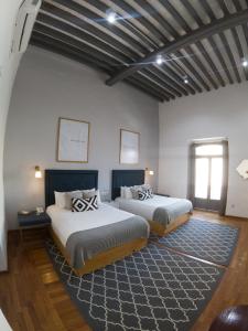1 dormitorio con 2 camas y alfombra en Markee Hotel Boutique, en Querétaro