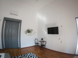 a white room with a door and a table and chairs at Markee Hotel Boutique Querétaro Centro Historico in Querétaro