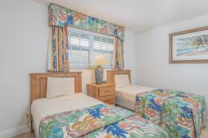 a bedroom with two beds and a window at Turtle Reef Club in Jensen Beach +24 photos