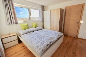 een kleine slaapkamer met een bed en een raam bij Appartement Sophia in Brixen im Thale