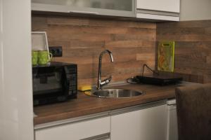 uma cozinha com pia e micro-ondas em As Lux Apartmani Kopaonik em Kopaonik