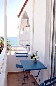 uma mesa azul e cadeiras numa varanda com o oceano em Stegna Akti Luxury Suites em Archangelos