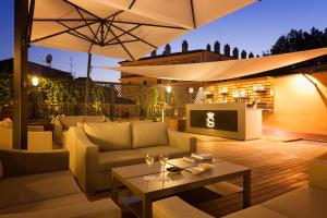 patio con divani, ombrellone e tavolo di Villa Spalletti Trivelli - Small Luxury Hotels of the World a Roma