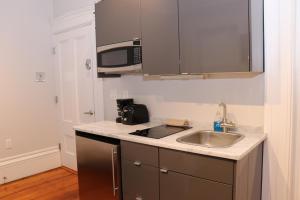 cocina con fregadero y microondas en Cozy Furnished Studio in Beacon Hill #4 en Boston