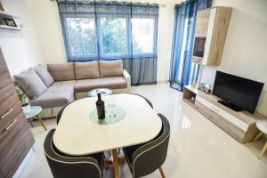 sala de estar con mesa y sofá en Apartman Mar, en Nin