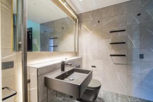 a bathroom with a sink and a toilet and a shower at Clarence Boutique Hotel in Tauranga