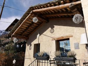 a building with awning and potted plants on it at Chambres d’hôtes La Latteria in Torgnon