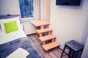 シュチェチンにあるApartamenty 21 Basicの小さなベッドルーム(ベッド1台、小さなテーブル付)