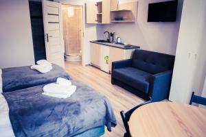 ein kleines Zimmer mit 2 Betten und einem Sofa in der Unterkunft Apartamenty 21 Basic in Stettin