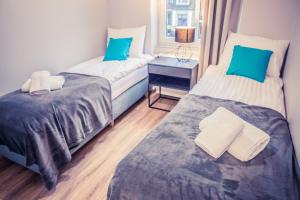 ein Zimmer mit zwei Betten und einem Tisch mit einer Lampe in der Unterkunft Apartamenty 21 Basic in Stettin