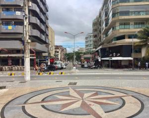 una calle de la ciudad con un gran reloj en medio de la calle en CABO FRIO - RJ - Praia do Forte, en Cabo Frío