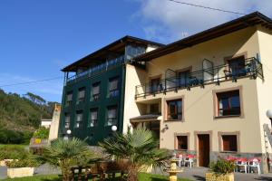 um edifício verde e branco em Hotel Restaurante Canero em Canero