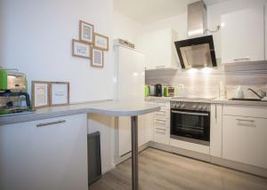 uma cozinha com armários brancos e uma bancada em Am Bergelchen 58-J em Winterberg