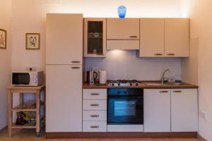 a kitchen with white cabinets and a stove at Appartamento Il Fattore in Levanto
