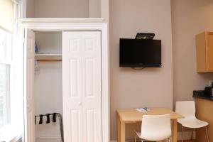 a door leading to a room with a table and a tv at Furnished Studio in the South End #4 in Boston