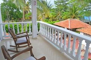 a porch with two chairs and an umbrella at Condominio Atlantis in Coveñas