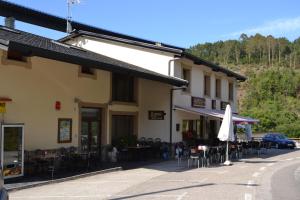 un edificio con mesas, sillas y sombrilla en Hotel Restaurante Canero, en Canero