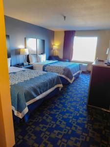 a hotel room with two beds and a flat screen tv at Days Inn & Suites by Wyndham Pocahontas in Pocahontas