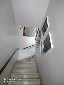 a stairway with pictures on the wall and a stair case at Dormitorios La Lucila Vicente Lopez Sol & Tren in La Lucila