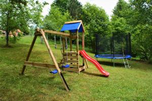 a playground with a slide and a swing set at Holiday Home Coprnička Hiša in Skrad