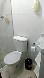 a white bathroom with a toilet and a shower at Residencial Bela Vista in Solemar