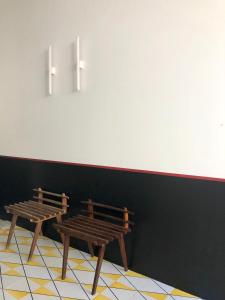 two wooden benches against a black wall with two lights at PrimoPianoPosillipo in Naples