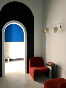 a room with a red chair and a window at PrimoPianoPosillipo in Naples