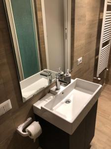 een badkamer met een witte wastafel en een spiegel bij Traiano guest house in Benevento