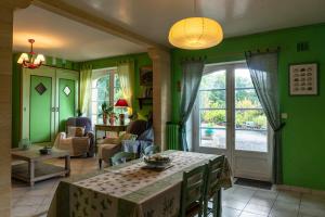 a living room with green walls and a table at Maison de charme à 5 km de Sarlat avec piscine in Carsac-Aillac