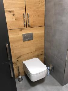 a bathroom with a white toilet and wooden cabinets at One-Of-A-Kind NASSFELD APARTMENTS in Sonnenalpe Nassfeld