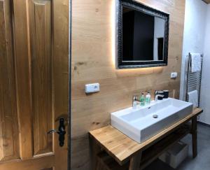 a bathroom with a sink and a tv on the wall at One-Of-A-Kind NASSFELD APARTMENTS in Sonnenalpe Nassfeld