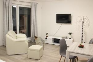 sala de estar blanca con mesa y comedor en Element Prag Airport Apartment, en Praga