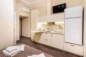 a kitchen with white cabinets and a white refrigerator at Rose d'Opera Hotel in Odesa +60 photos