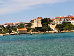 a group of boats in the water next to a castle at Apartamentos da Vila - Duna Parque Resorts & Hotels in Vila Nova de Milfontes