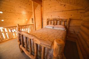 1 dormitorio con 1 cama en una cabaña de madera en The Pines at Island Park, en Island Park