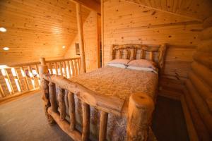 ein Schlafzimmer mit einem Bett in einer Blockhütte in der Unterkunft The Pines at Island Park in Island Park