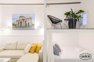uma sala de estar com um sofá branco e uma fotografia em Charming Puerta de Toledo II em Madri