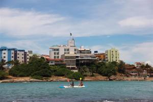 two people are on a paddle board in the water at Pousada Barlavento in Iriri