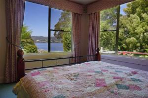 a bed sitting in front of a window next to a tree at Donalea Bed and Breakfast & Riverview Apartment in Castle Forbes Bay