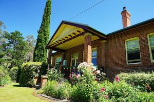 a brown brick house with a garden in front of it at Donalea Bed and Breakfast & Riverview Apartment in Castle Forbes Bay