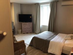 Saint-Léger-en-Yvelines的住宿－樂切內彭德拉根酒店，一间卧室配有一张床和一台平面电视