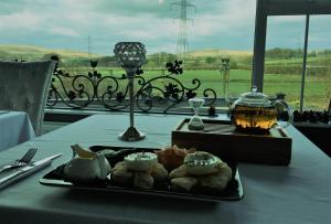a table with a plate of food on a table with a table cloth at Dunamoy Cottages & Spa in Ballyclare