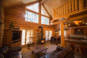 a living room with a couch and a fireplace in a log cabin at The Pines at Island Park in Island Park